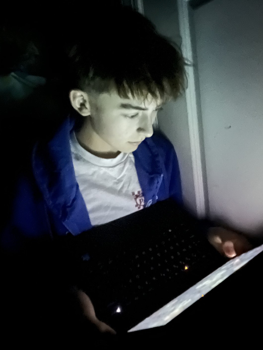 A person on their laptop at late night in a dark room